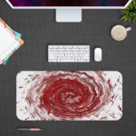 Infidu Artistic Desk Pad with a swirling vortex pattern in red, white, and black. Desk Mat Design Kept on a computer table