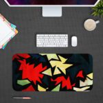 Infidu Artistic Patterns Desk Pad with sharp, jagged shapes in a zigzag design featuring bold colors like red, white, green, and black. Desk Pad with Design Kept on a computer table