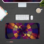 Infidu Artistic Patterns Desk Pad features a vibrant spiral design with rich colors including deep reds, oranges, yellows, purples, and blues. Desk Pad with Design Kept on a computer table