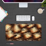 Infidu Artistic Patterns Desk Pad with a dark brown and black wave-like pattern highlighted with golden accents, creating a warm glow. Desk Pad with Design Kept on a computer table