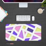 Infidu Artistic Desk Pad with geometric design in pastel pink, purple, blue, and yellow on a light background. Desk Mat Design Kept on a computer table