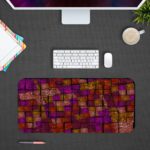 Infidu Artistic Patterns Desk Mat with a dark red and maroon background and a mosaic grid pattern in shades of orange, brown, and yellow. Desk Pad with Design Kept on a computer table