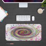 Infidu Artistic Desk Pad with a rainbow spiral and multicolored splatter on a white background. Desk Mat Design Kept on a computer table