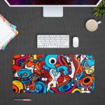 Desk pad with a vibrant, abstract cartoon doodle design featuring bold colors and playful shapes. Design Kept on a computer table