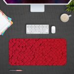 Infidu Artistic Patterns Desk Pad with a red background and intricate circle vector pattern. Design Kept on a computer table