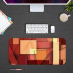 Infidu Artistic Desk Mat with an abstract composition of overlapping rectangular shapes in red, orange, and beige tones. Desk Mat Design Kept on a computer table