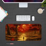 Desk pad featuring a colorful sunset over a forest, with warm shades of red, orange, and yellow. Trees in the foreground and a glowing sun in the sky. Design Kept on a computer table