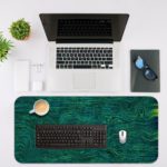 Blue-green swirled abstract design with fluid, wavy lines resembling water or marble. Desk Mat with an Apple Laptop