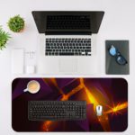 Desk pad with a dark purple background and overlapping triangular shapes in orange and yellow, creating depth and movement. Desk Mat with a laptop