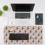 Desk pad with a white background featuring a pattern of small blue and purple flowers or geometric shapes. Desk Mat with a laptop