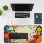 Infidu Color Splash Animated Desk Pad featuring a bubble-like pattern with red, blue, and orange colors on an abstract, marbled background. Desk Mat with an Apple Computer