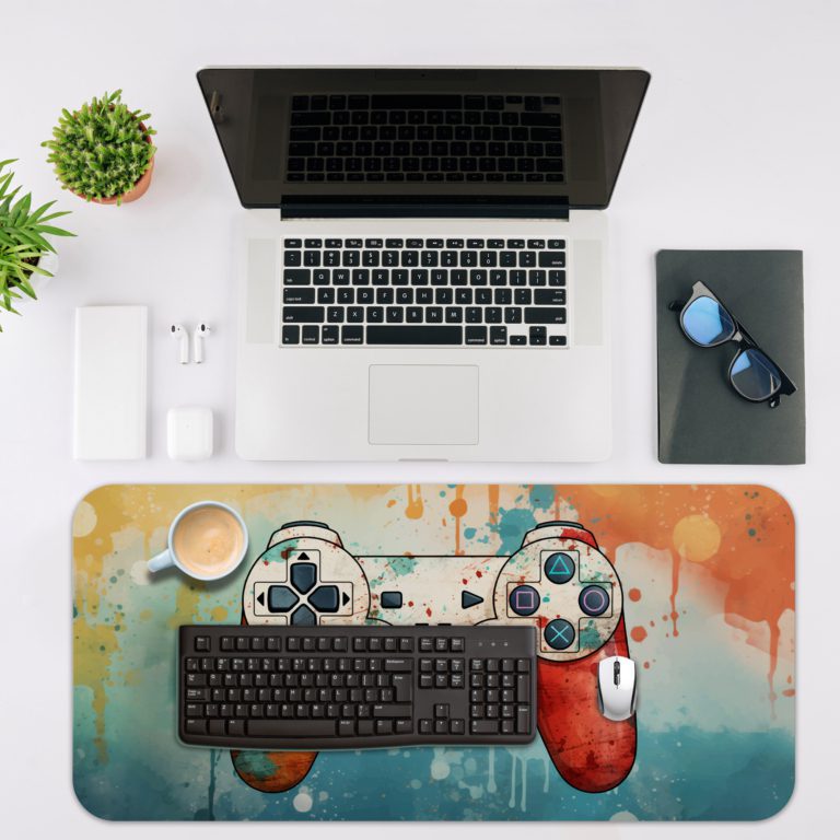 Gaming Desk Pad featuring a blue and orange controller with a blue and yellow right side, set against a vibrant background of blue, orange, and yellow paint splashes. Desk Mat with an Apple Computer