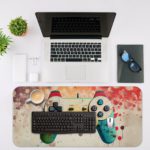 Gaming desk pad featuring a uniquely painted, colorful controller in bright green, sunny yellow, and cool blue, with an energetic background of paint splashes in reds, pinks, and oranges Desk Mat with an Apple Computer