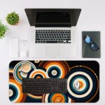 Infidu Artistic Desk Mat with concentric orange and white circular patterns on a dark blue or black background. Desk Mat with an Apple Laptop