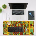 Infidu Artistic Patterns Desk Mat featuring a detailed geometric grid in earthy tones like green, yellow, red, and brown. Desk Mat with an Apple Laptop