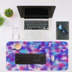 Infidu Artistic Patterns Desk Pad with a multi-colored speckled design in blue, pink, purple, and white, resembling a watercolor effect. Desk Mat with an Apple Laptop