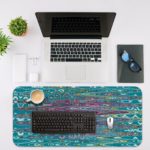 Infidu Artistic Patterns Desk Mat with a blue and teal wavy pattern that resembles water reflections. Desk Mat with an Apple Laptop