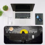 Infidu Artistic Desk Pad with a shadowy anthropomorphic cat or wolf riding a bicycle against a city skyline and a large yellow moon. Desk Mat with an Apple Laptop