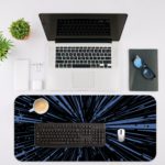 Infidu Minimalist Design Desk Pad features a blue and black background with abstract vector art, resembling speed lines or a starburst effect. Desk Mat with in laptop