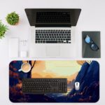 Desk pad featuring a person sitting by a tree, with a calm view of mountains and water in soft orange, blue, and purple tones. Desk Mat with an Apple Laptop