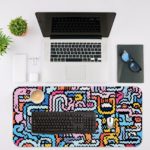 Colorful abstract maze design desk pad with wavy lines in blue, pink, yellow, white, and black on a light blue background. Desk Mat with an Apple Laptop