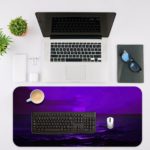 Tranquil ocean scene in purple twilight with gentle waves and a distant silhouette, creating a dreamy atmosphere. Desk Mat with an Apple Laptop