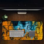 Infidu Artistic Desk Mat with an abstract geometric pattern in yellow, orange, and blue, covering the entire surface. Desk Pad with Design Kept on a computer table