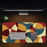 Infidu Artistic Patterns Desk Pad with overlapping curved shapes in maroon, beige, teal, and brown. Desk Pad in computer table