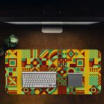 Infidu Artistic Patterns Desk Mat featuring a detailed geometric grid in earthy tones like green, yellow, red, and brown. Desk Pad in computer table