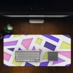 Infidu Artistic Desk Pad with geometric design in pastel pink, purple, blue, and yellow on a light background. Desk Pad in computer table