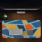 Infidu Artistic Pattern Desk Pad - Blue background with abstract shapes in orange, yellow, and light blue Desk Pad on computer table