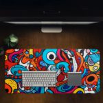 Desk pad with a vibrant, abstract cartoon doodle design featuring bold colors and playful shapes. Desk Pad in computer table