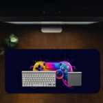 Gaming Desk Pad featuring a colorful controller in pink, blue, and yellow on a navy blue background, designed for a vibrant and unique gaming setup Desk Pad with Antique Video Game Design Desk Pad on computer table