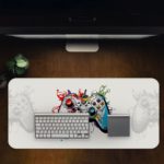 Gaming Desk Pad featuring a multi-colored controller on a mainly white background, designed for a unique and artistic look Desk Pad with Antique Video Game Design Kept on a computer table