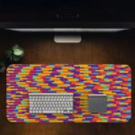 Infidu Artistic Desk Pad with a colorful mosaic pattern of red, yellow, blue, purple, and orange blocks arranged diagonally. Desk Pad in computer table