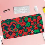 Desk pad with an abstract pattern of overlapping circles and swirls in red, green, and dark blue. Desk Pad with Keyboard and Mouse