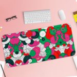 Colorful abstract desk pad with playful patterns, featuring pink, green, red, black, and white shapes resembling flowers and circles. Desk Pad with Keyboard and Mouse