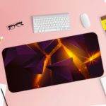 Desk pad with a dark purple background and overlapping triangular shapes in orange and yellow, creating depth and movement. Desk Pad with Keyboard and Mouse