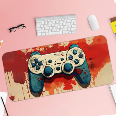 Infidu Tech Fusion With Joystick Desk Pad featuring an artistic game controller in orange and red, with a colorful sandal orange background and vibrant paint splashes Desk Pad kept on a pink background