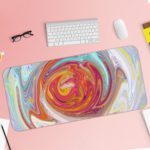 Abstract swirl pattern with vibrant red, yellow, purple, and blue colors on a light blue and white background. Desk Pad with Keyboard and Mouse