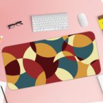 Infidu Artistic Patterns Desk Pad with overlapping curved shapes in maroon, beige, teal, and brown. Desk Pad with Keyboard and Mouse