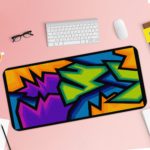 Infidu Artistic Patterns Desk Mat with sharp, angular shapes in purple, blue, green, orange, and black resembling graffiti. Desk Pad with Keyboard and Mouse