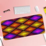 Infidu Artistic Patterns Desk Mat with 3D overlapping diamond shapes in gradient shades of purple, orange, and yellow. Desk Pad with Keyboard and Mouse