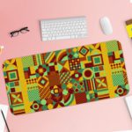 Infidu Artistic Patterns Desk Mat featuring a detailed geometric grid in earthy tones like green, yellow, red, and brown. Desk Pad with Keyboard and Mouse