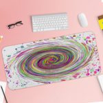 Infidu Artistic Desk Pad with a rainbow spiral and multicolored splatter on a white background. Desk Pad with Keyboard and Mouse