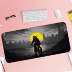 Infidu Artistic Desk Pad with a shadowy anthropomorphic cat or wolf riding a bicycle against a city skyline and a large yellow moon. Desk Pad with Keyboard and Mouse