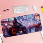 Desk pad featuring a stylish biker on a red-wheeled motorcycle with a blurry blue and purple urban background. Desk Pad with Keyboard and Mouse