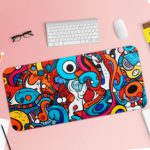 Desk pad with a vibrant, abstract cartoon doodle design featuring bold colors and playful shapes. Desk Pad with Keyboard and Mouse