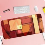 Infidu Artistic Desk Mat with an abstract composition of overlapping rectangular shapes in red, orange, and beige tones. Desk Pad with Keyboard and Mouse