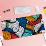 Infidu Desk Pad with colorful wave patterns in orange, blue, white, and red. Desk Pad with Keyboard and Mouse